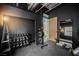Home gym showcasing free weights, weight racks, a bench, and a mirror in a room with dark walls at 5077 Thunder River Cir, Las Vegas, NV 89148