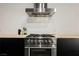 Stainless steel oven and cooktop with black cabinets and butcher block countertops at 5077 Thunder River Cir, Las Vegas, NV 89148