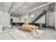 Bright open-plan living area featuring concrete floors, high ceilings, a modern staircase and unique light fixtures at 5077 Thunder River Cir, Las Vegas, NV 89148