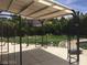 Landscaped backyard with covered patio, iron fencing, view of green grass and large mature trees at 5147 Villa Vecchio Ct, Las Vegas, NV 89141