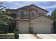 Two-story stucco home with a terracotta tile roof, manicured landscaping, and a two-car garage at 5147 Villa Vecchio Ct, Las Vegas, NV 89141