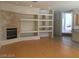 Spacious living room featuring a fireplace, built-in shelves, and hardwood floors at 5147 Villa Vecchio Ct, Las Vegas, NV 89141