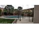 Backyard pool area with a decorative iron shade, manicured lawn, and stone landscaping for a relaxing oasis at 5147 Villa Vecchio Ct, Las Vegas, NV 89141