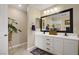 Bathroom featuring double sinks, modern fixtures, a shower and tile flooring at 5213 Welch Valley Ave, Las Vegas, NV 89131