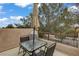 Cozy patio with table, chairs, umbrella, and partial view of trees under a partly cloudy, blue sky at 5213 Welch Valley Ave, Las Vegas, NV 89131