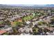 Wide aerial view of a desert golf community surrounding a brown roofed house and lush landscaping at 5240 Las Cruces Dr, Las Vegas, NV 89130