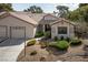 Inviting home exterior with manicured front yard and two-car garage at 5240 Las Cruces Dr, Las Vegas, NV 89130