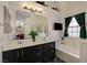 Bright bathroom featuring a dual sink vanity, a soaking tub, and a large window at 5508 Lochmor Ave, Las Vegas, NV 89130