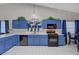 Spacious kitchen with blue cabinets, black appliances and adjacent dining area at 5508 Lochmor Ave, Las Vegas, NV 89130