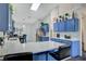 Modern kitchen with white counters, blue cabinets, and bar stool seating at 5508 Lochmor Ave, Las Vegas, NV 89130