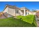 Spacious backyard with lush turf, desert landscaping, patio, and community views at 56 Tatahatso Point St, Henderson, NV 89011