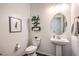 Charming powder room featuring a pedestal sink, decorative accents, and modern fixtures at 56 Tatahatso Point St, Henderson, NV 89011