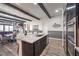 Open-concept kitchen featuring a marble island, stainless steel appliances, and wood-look tile flooring at 56 Tatahatso Point St, Henderson, NV 89011
