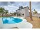 Backyard with an in-ground pool, covered patio, desert landscaping, and two-story home at 5629 Caladonia Ave, Las Vegas, NV 89110