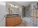 Bathroom featuring granite counters, stone accents, and tub with shower at 619 Ancient Mayan Dr, Henderson, NV 89015