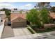 Charming single-story home with a well-manicured lawn, a large driveway, and a two-car garage at 619 Ancient Mayan Dr, Henderson, NV 89015