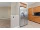 Kitchen area features stainless steel refrigerator, custom cabinetry, granite counter, and tiled floors at 619 Ancient Mayan Dr, Henderson, NV 89015