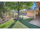 A relaxing backyard featuring a mature shade tree and artificial grass at 6225 Sadler Dr, Las Vegas, NV 89130