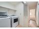 Well-lit laundry room featuring a washer, dryer, shelving, and tile flooring at 6225 Sadler Dr, Las Vegas, NV 89130