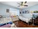 Comfortable bedroom with hardwood floors, large window, and ceiling fan for added comfort at 680 Cervantes Dr, Henderson, NV 89014