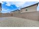 Gravel-covered backyard with a small brick patio and block wall, offering low maintenance and privacy at 7006 Sylmar Ave, Las Vegas, NV 89113