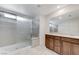 Bathroom featuring a double sink vanity with wood cabinets and a glass door shower at 7006 Sylmar Ave, Las Vegas, NV 89113