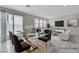 Virtually staged dining area featuring a glass table with gold accents and seating for six, adjacent to living room at 7006 Sylmar Ave, Las Vegas, NV 89113
