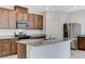 Well-equipped kitchen with stainless steel appliances, granite counters, island and wood cabinets at 7006 Sylmar Ave, Las Vegas, NV 89113