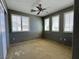 Carpeted bedroom with neutral paint, ceiling fan, and bright shuttered windows at 7173 Dravite Ct, Las Vegas, NV 89148