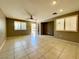 Spacious living room with neutral paint, tile flooring, and abundant natural light from the shuttered windows at 7173 Dravite Ct, Las Vegas, NV 89148