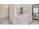 Sleek bathroom featuring dual sinks, a large mirror, neutral decor, and an open view into the bedroom at 7320 N Decatur Blvd # 5, Las Vegas, NV 89131