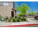 Charming exterior of a modern townhome featuring a stone accent wall, lush landscaping, and community pool access at 7320 N Decatur Blvd # 5, Las Vegas, NV 89131