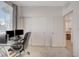 Well-lit office with dual monitors, glass desk, closet, and neutral-toned walls and carpet at 7320 N Decatur Blvd # 5, Las Vegas, NV 89131