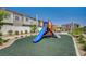 Fun community playground with a slide for children to enjoy, surrounded by green landscaping and residential buildings at 7320 N Decatur Blvd # 5, Las Vegas, NV 89131