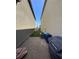 Narrow backyard with some stones, grass, air conditioner, and trash bins at 7323 Sunray Point St, North Las Vegas, NV 89084