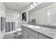 Bright bathroom with granite countertop and tiled shower at 7323 Sunray Point St, North Las Vegas, NV 89084