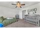 Bright bedroom with carpet, neutral paint, ceiling fan, and large name decal on wall at 7323 Sunray Point St, North Las Vegas, NV 89084