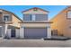 Two story home featuring gray garage door, well maintained landscape and driveway at 7323 Sunray Point St, North Las Vegas, NV 89084