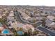 Expansive aerial view of a residential neighborhood, featuring houses, streets, palm trees, and a mountain range backdrop at 810 Roaring Falls Ave, Henderson, NV 89052