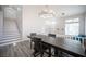 Dining area with a modern chandelier, a large table, and an adjacent staircase with light filled windows at 810 Roaring Falls Ave, Henderson, NV 89052
