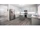 Bright kitchen featuring white cabinets, stainless steel appliances, an island, and wood-look flooring at 810 Roaring Falls Ave, Henderson, NV 89052