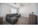 Cozy living room with a gray sectional couch, wood floors, and an airy atmosphere for relaxing or entertaining guests at 810 Roaring Falls Ave, Henderson, NV 89052