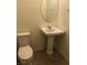 Half bath featuring white toilet, pedestal sink and oval mirror at 8111 Switchback Run St, Las Vegas, NV 89166