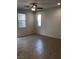 Tiled empty bedroom with two bright windows and ceiling fan at 8111 Switchback Run St, Las Vegas, NV 89166