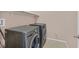 This laundry room is equipped with gray LG washer and dryer and storage shelf above at 8220 Redbud Vine St, North Las Vegas, NV 89085