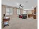 Open-concept living room showcasing plush carpet, ceiling fan, and an adjoining kitchen and dining area at 8220 Redbud Vine St, North Las Vegas, NV 89085