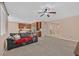 Spacious open-concept living area with plush carpet, a ceiling fan, and an adjoining kitchen perfect for entertaining at 8220 Redbud Vine St, North Las Vegas, NV 89085