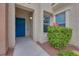 Townhome entry with blue door, window, and green shrub at 840 Picotte St # 101, Las Vegas, NV 89144