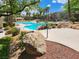 Resort-style community pool area with lush landscaping, palm trees, cabana, and inviting, cool blue water at 840 Picotte St # 101, Las Vegas, NV 89144