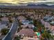 An aerial view of a community with mature landscaping, golf course, mountain views, and multiple in-ground pools at 8808 Rozetta Ct, Las Vegas, NV 89134
